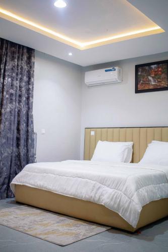 a bedroom with a large bed and a window at Emerald Apartments in Lagos