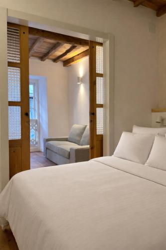 a bedroom with a white bed and a couch at Alcacer 4-1 in Puentedeume