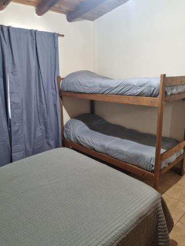 a room with two bunk beds and a bed at Refugio del Valle - Uspallata in Uspallata