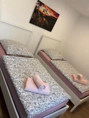 two beds with slippers on them in a room at Casa Tua An der Weinstraße in Neustadt an der Weinstraße