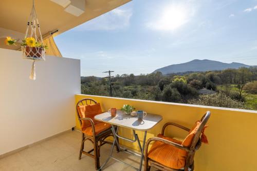 a balcony with a table and chairs and a view at Katerina's Sunset Apartment in Episkopianá