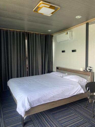 a bedroom with a large bed with white sheets at Tawan Resort in Bophut