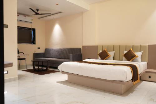 a bedroom with a bed and a couch at Shri Prasad Executive in Pandharpur