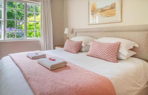 a bedroom with a large bed with two towels on it at Lloyd Road Cottage in Port Elizabeth