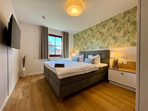 a bedroom with a bed and a television in it at Oewern Diek App 52 in Wustrow