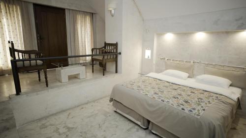 a bedroom with a large bed and a bathroom at Kasr-i Nehroz Hotel in Midyat