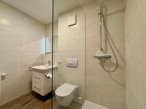 a bathroom with a toilet and a shower at Oewern Diek App 52 in Wustrow