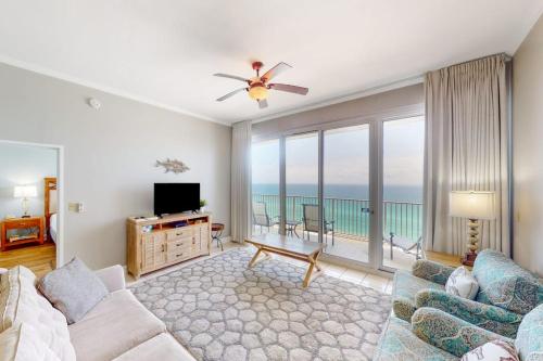 a living room with a couch and a tv at Gulf-Front Condo with Pools and Gym in Destin