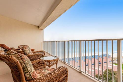 a balcony with wicker chairs and a view of the beach at Relaxing Waterfront Condo with Pools & Gym Access in Destin