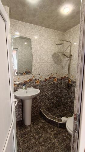 a bathroom with a sink and a shower and a mirror at Kutchak AparanQ in Kʼuchʼak