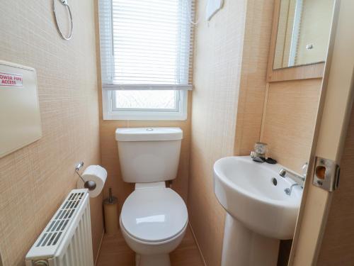 a small bathroom with a toilet and a sink at Winchester - 244 in Rhyl