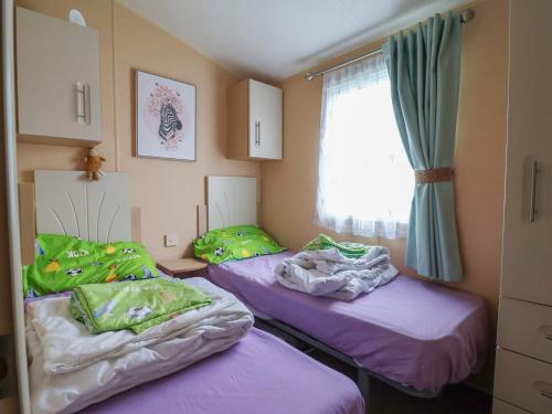 two twin beds in a room with a window at Winchester - 244 in Rhyl