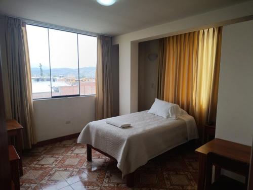 a bedroom with a bed and a large window at Kibo Hotel in Ayacucho