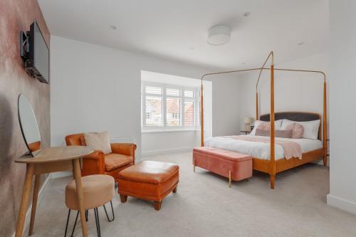 a bedroom with a canopy bed and a chair at The Laurels by Grandeur Property in Poole