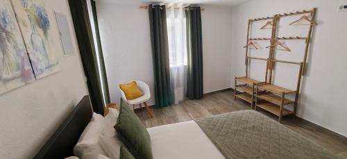 a bedroom with a bed and a chair in a room at Casa da Avó Biza in São Roque do Pico