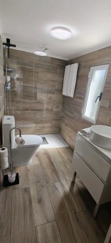 a bathroom with a sink and a tub and a toilet at Casa da Avó Biza in São Roque do Pico