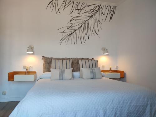 ein Schlafzimmer mit einem großen weißen Bett und zwei Tischen in der Unterkunft Hotel Cap d'Or - Children only from 15 years old in Tossa de Mar
