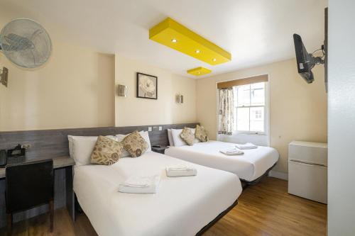 a room with two beds and a couch at Linden House Hotel in London