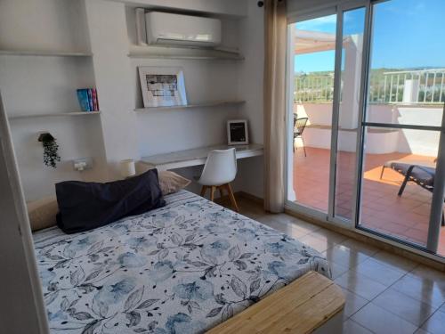 a bedroom with a bed and a balcony at Ático en Estepona, Malaga in Estepona