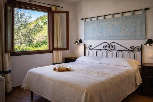 a bedroom with a large bed and a window at Giardini Malaspina in Bosa