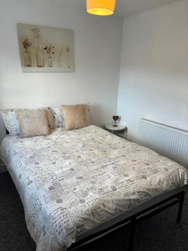 a bedroom with a bed with a comforter on it at Middlecroft in Chesterfield