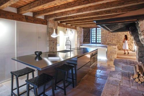 a kitchen with a large island with black bar stools at Le Torri di Credazzo in Farra di Soligo