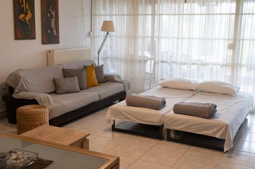 a living room with two beds and a couch at Sea Breeze Alexandroupolis in Alexandroupoli