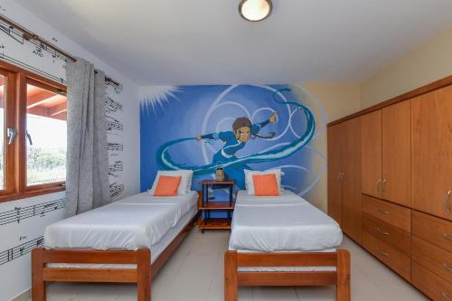 two beds in a room with a painting on the wall at Arantxa Residence in Noord