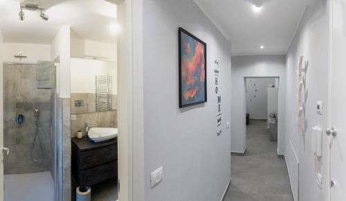 a white bathroom with a sink and a shower at La Perla sul Lago in Pescate