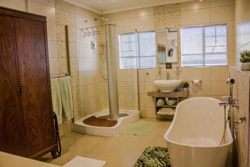 a bathroom with a shower and a toilet and a sink at Kruger's Rest Guest House in Hazyview