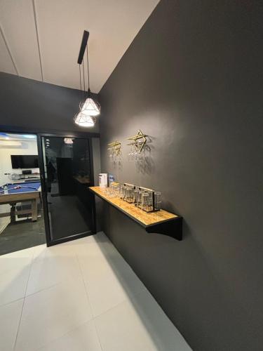 a black wall with a counter with glasses on it at 65 Poolvilla in Ban Tao Than