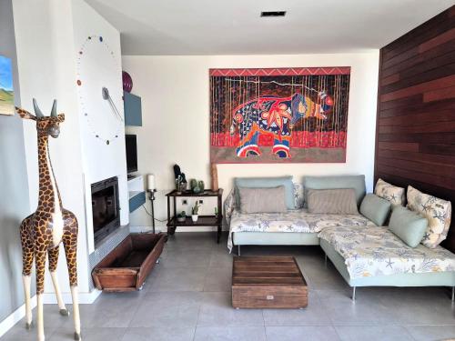 Una sala de estar con un sofá y un cuadro de jirafa. en CASA LA ROCA, en Agua Amarga