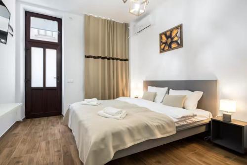 a bedroom with a bed with two towels on it at RHUM B07 - Old Town Courtyard in Bucharest