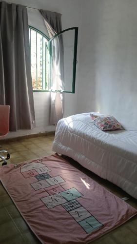 a bedroom with a bed and a rug on the floor at Refugio del Limonero - Colonial y Cercano in Córdoba