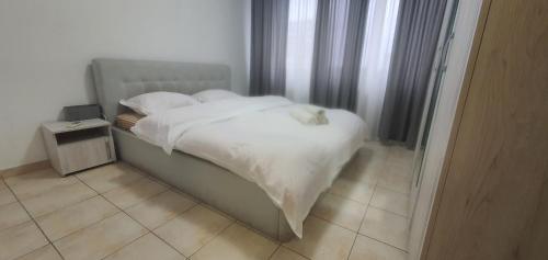 a bed with white sheets and pillows in a bedroom at 5th Floor Oasis 2 Badroom Apartment in Bucharest