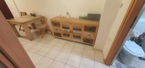 a bathroom with a wooden cabinet and a toilet at 5th Floor Oasis 2 Badroom Apartment in Bucharest