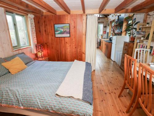 a bedroom with a bed in a wooden room at Cosy Eco Cabin in Newport