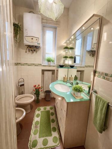 a bathroom with a sink and a toilet and a mirror at ADAapartmenthousesalerno in Salerno