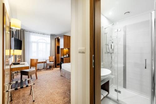 a bathroom with a shower and a toilet and a sink at Hotel Lord - Warsaw Airport in Warsaw