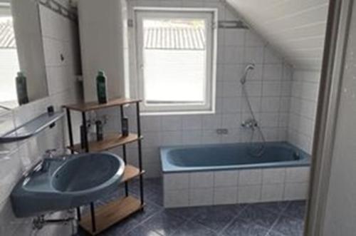 a bathroom with a tub and a sink and a window at Henrik's Ferienwohnung in Öblarn