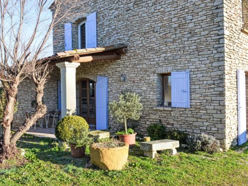 a brick house with a blue door and some plants at Apartment Le Platane by Interhome in Velleron