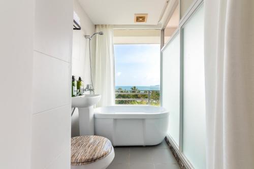 a bathroom with a tub and a sink and a window at Yumian Cloud Seaview Hotel in Sanya