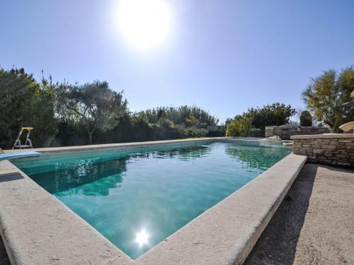 a large swimming pool with blue water at Holiday Home Le Real by Interhome in Velleron