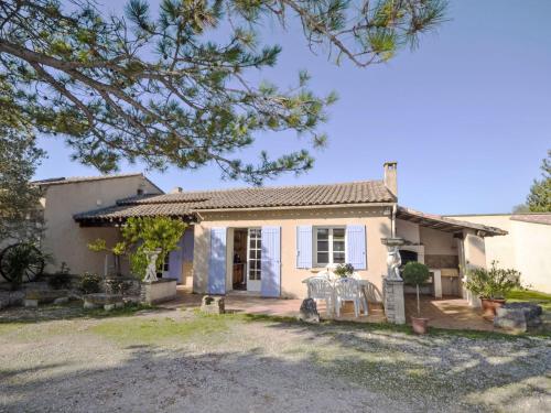 a small white house with a table in front of it at Holiday Home Le Real by Interhome in Velleron
