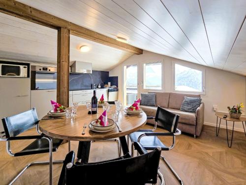 a dining room with a table and chairs and a kitchen at Apartment LiloTopMountainView by Interhome in Beatenberg