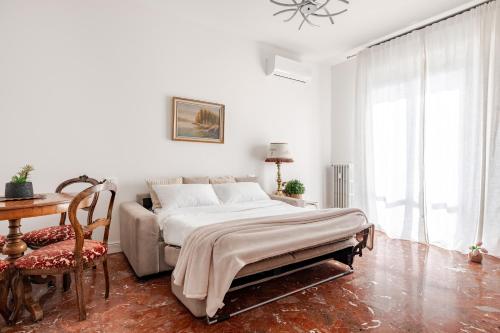 a bedroom with a bed and a table and a chair at Casa Bra-Z 10m da Arena Verona e Stazione Porta Nuova - 7Px in Verona