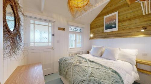 a bedroom with a bed and a wooden ceiling at F12 West View, Riviere Towans in Hayle