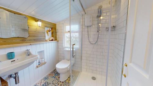 a bathroom with a toilet and a sink and a shower at F12 West View, Riviere Towans in Hayle