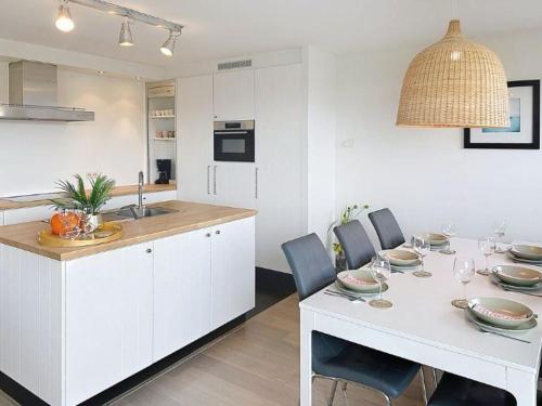 a kitchen and dining room with a white table and chairs at Apartment Albatros with parking by Interhome in Bredene