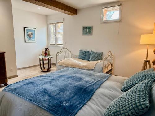 a bedroom with two beds and a window at Moulin de Bas Couleur in Villedômer